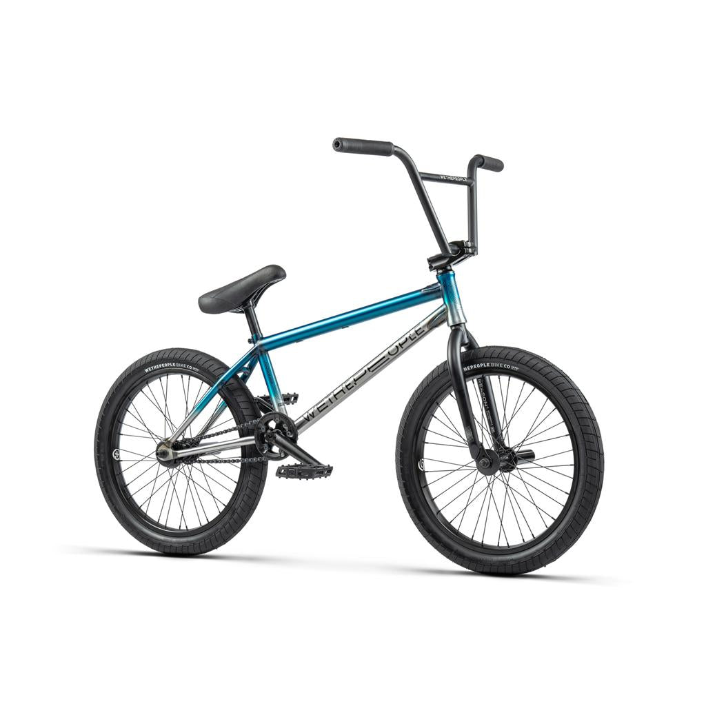 The Wethepeople Reason Shift 20 Inch Bike is a premium blue BMX with black tires, pedals, and seat, plus a hybrid freecoaster cassette, shown from the side on a white background.