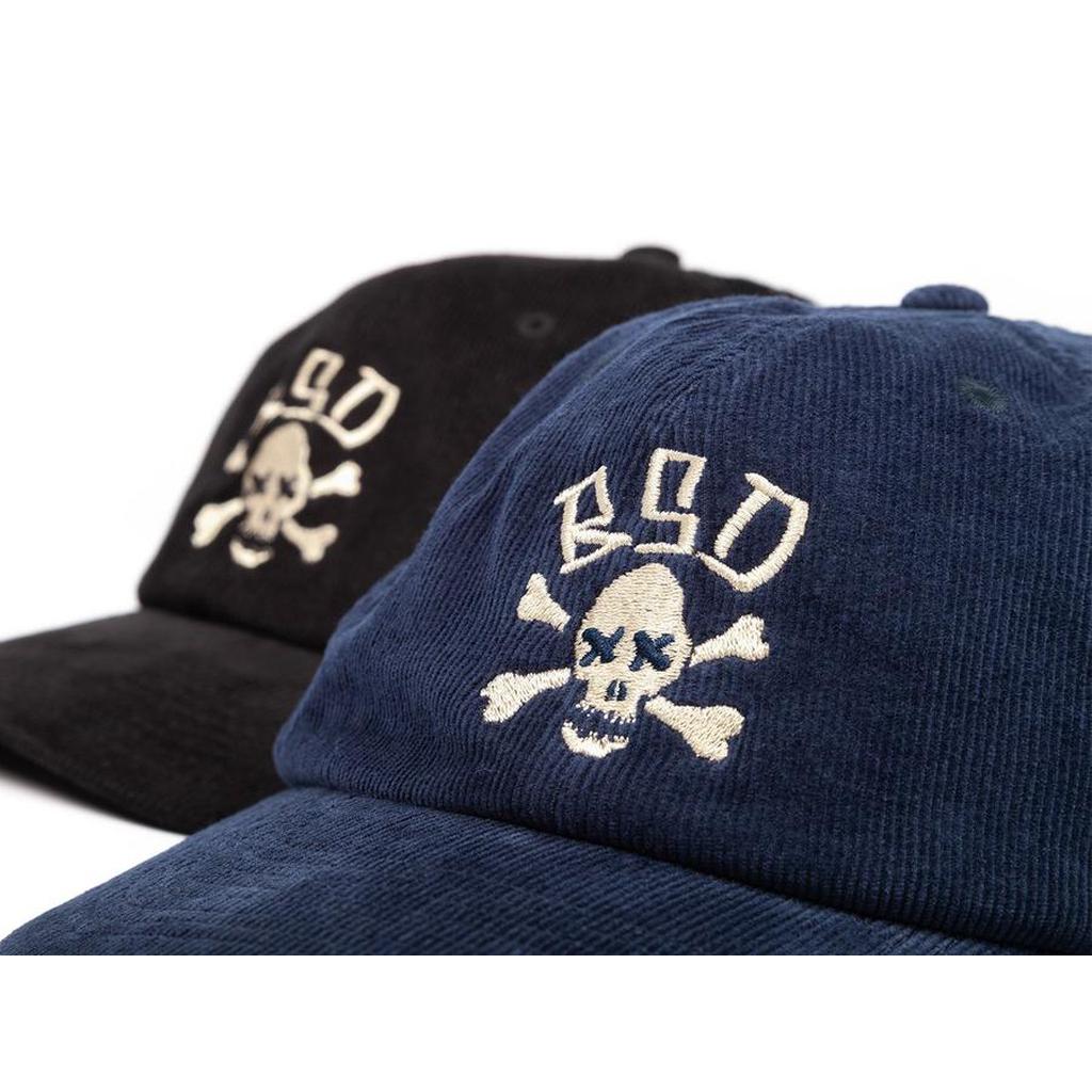 Two BSD More Speed Caps—6-panel corduroy in black and navy—each with an embroidered skull and crossbones plus "BSD" above. Classic headwear for any BSD More Speed fan.
