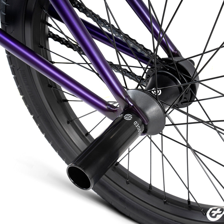 A close up of a purple bike wheel with black spokes, perfect for urban warriors who ride the Wethepeople Reason 20 Inch BMX Bike.
