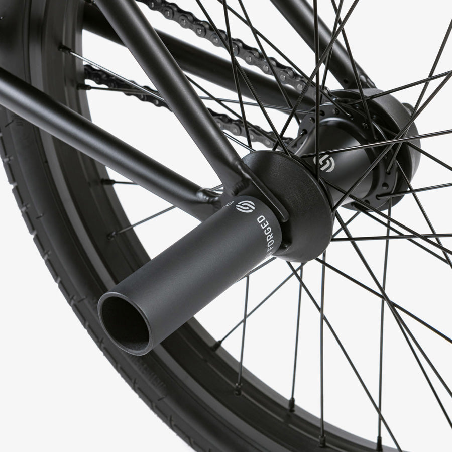 A close up of a black BMX bike wheel, showcasing the sleek design of the Wethepeople Reason 20 Inch BMX Bike street machine.