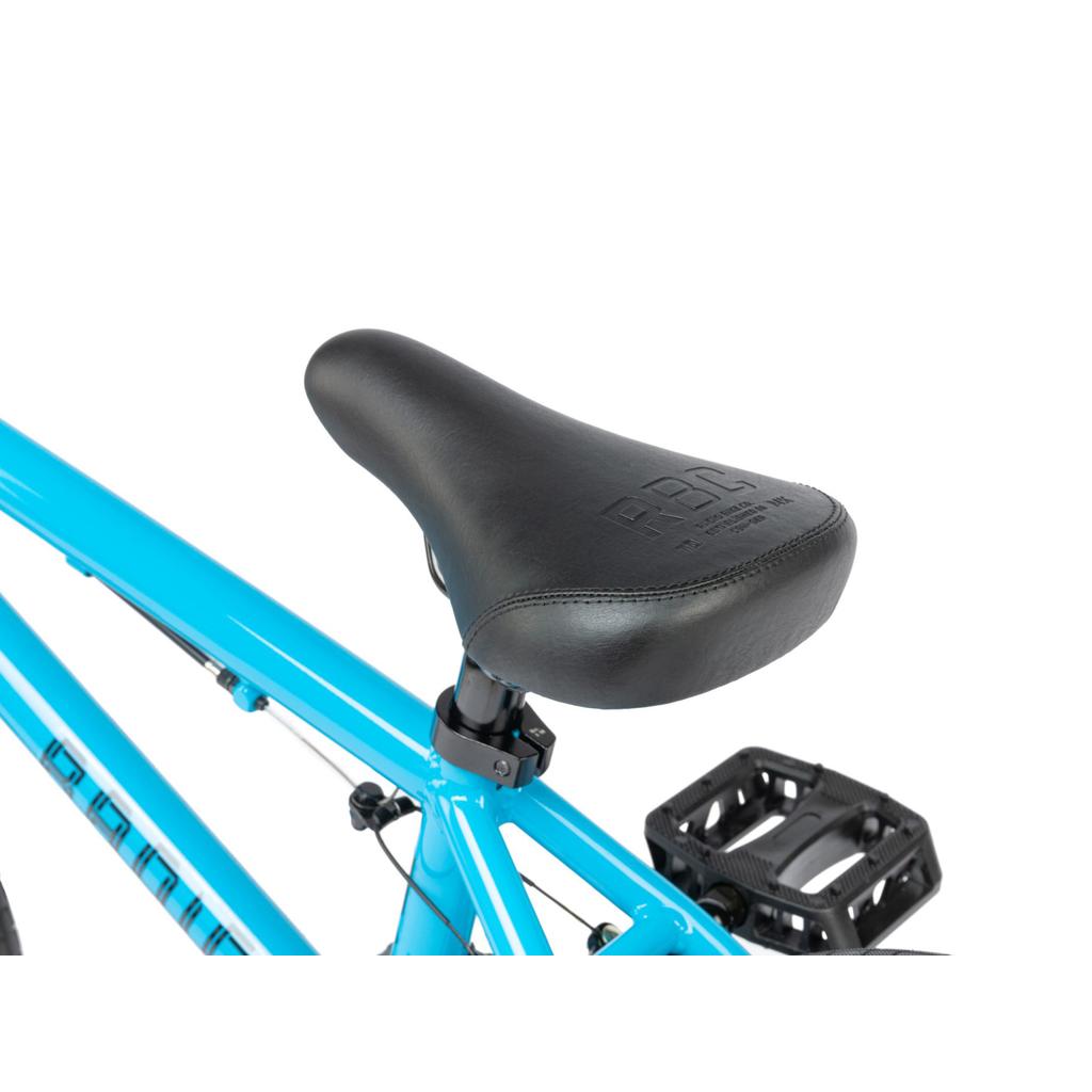 Close-up of a black seat attached to a blue frame, with part of a black pedal showing—ideal for an outdoor children’s bicycle like the Radio Revo 16 Inch Bike.