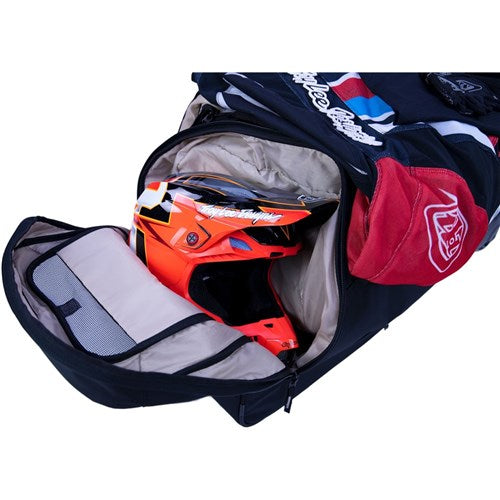 The Albek Meridian Wheeled Gear Bag, shown partially unzipped, displays an orange and black helmet and clothing inside—ideal for storing your protective gear.