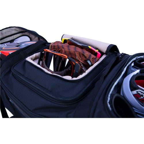 The Albek Meridian Wheeled Gear Bag in black features an open compartment showing a brown baseball glove and sunglasses, with other sports gear nearby. Its waterproof lining keeps your protective gear safe and dry.