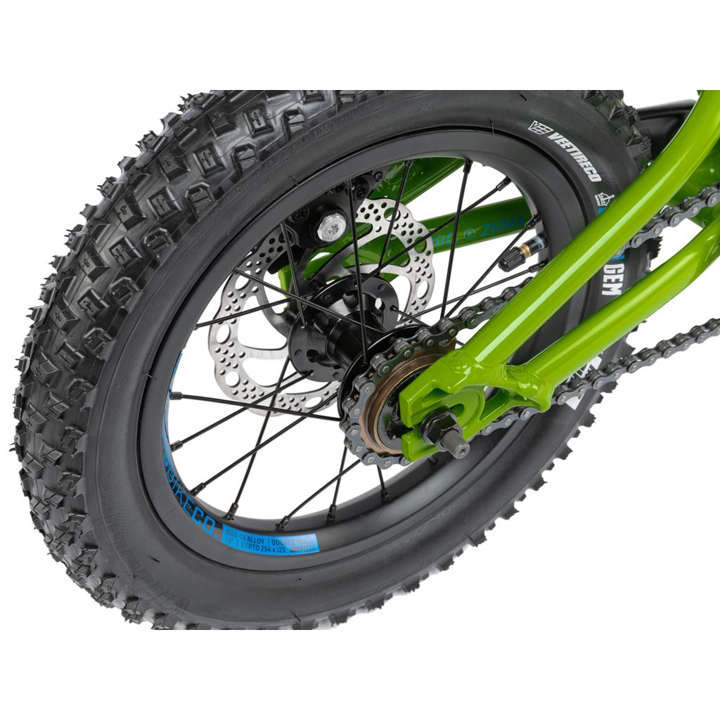 Close-up of the Radio Zuma 14 Inch Bike’s green rear fat tire and wheel, highlighting the disc brake, chain, sprocket, and knobby tread pattern designed for rugged kids’ adventures.