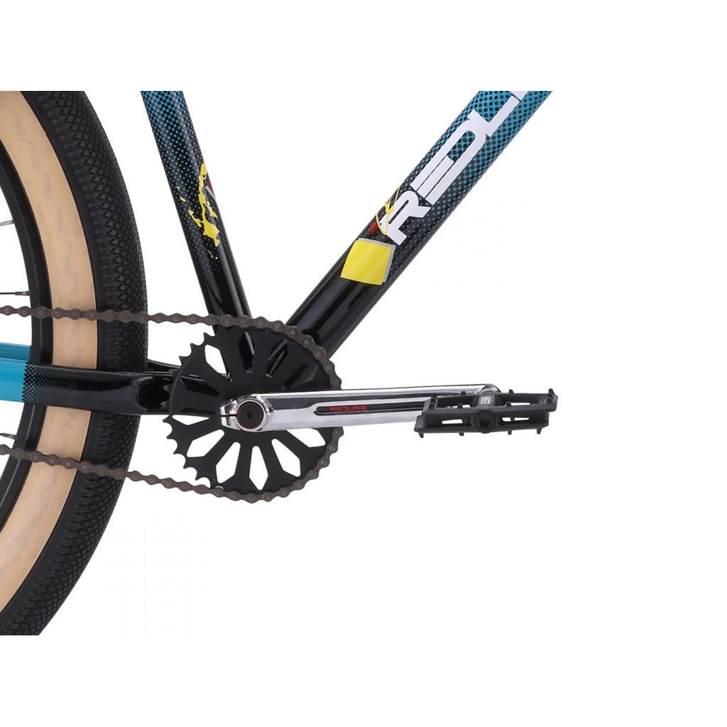 Close-up of the Redline RL 275 27.5 Inch Bike's retro BMX cruiser drivetrain, highlighting the chain, black chainring, pedal, and a rear wheel with a tan sidewall tire.