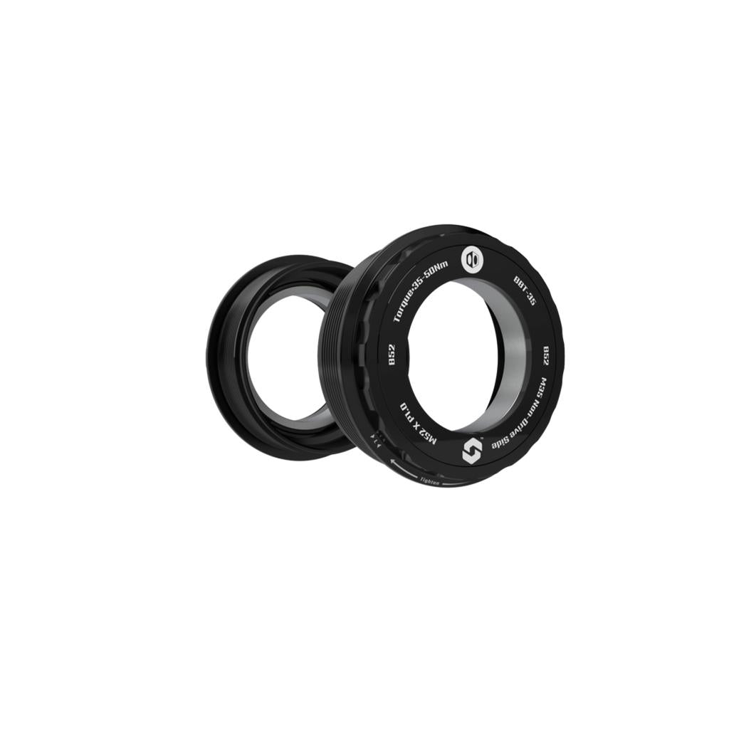 Two black circular Box ONE Bottom Bracket B52 35mm mechanical seals with white labeling shown at an angle against a white background—perfect for enhancing power transfer in compatible bike systems.