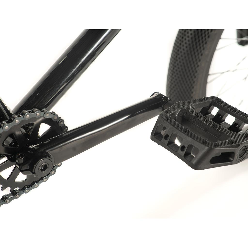 Close-up of the black crankset, chainring, and black plastic pedal on the Cult Access 20 Inch Bike, a top choice for beginner BMX riders, shown against a white background.
