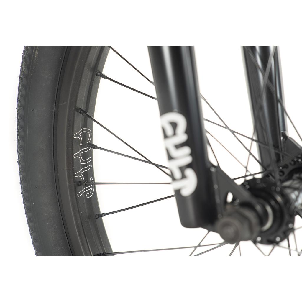 Close-up of a black 20-inch BMX wheel and fork with white "CULT" branding, showcasing spokes and tire on a white background—perfect for anyone interested in the Cult Access 20 Inch Bike as an entry-level BMX.