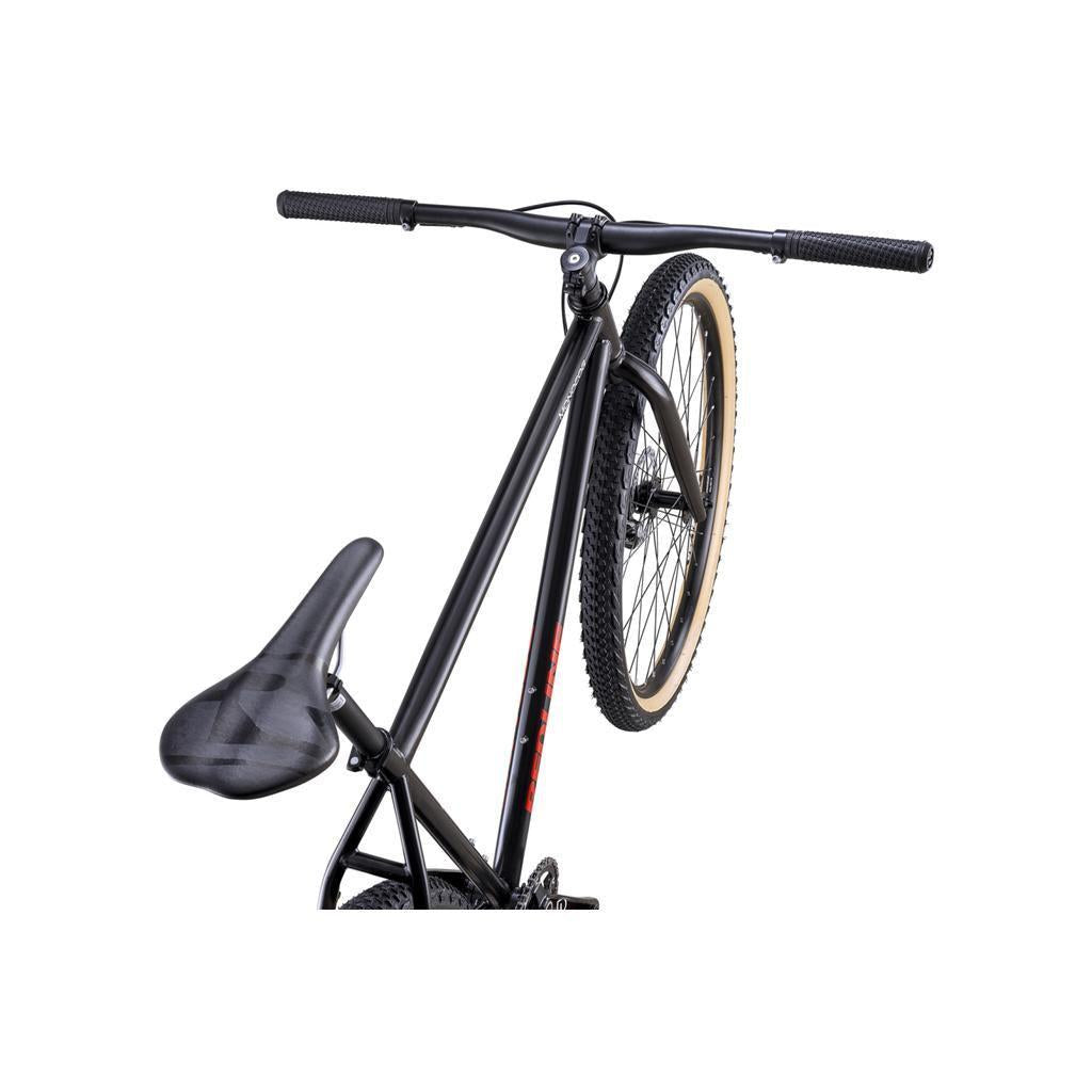 A Redline Monocog 29 Inch Bike in black is depicted from a rear side angle, with one wheel raised and the handlebars slightly turned.