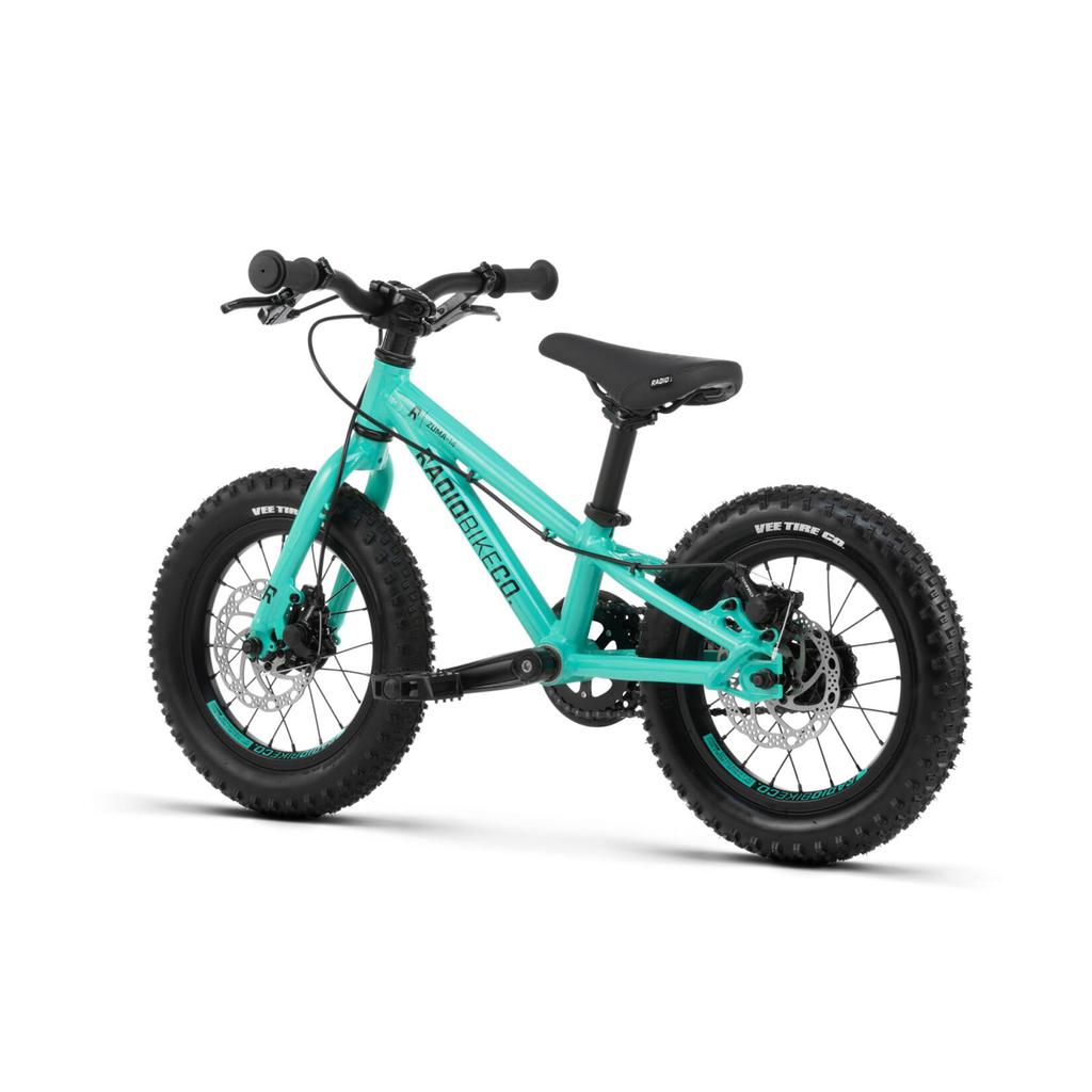 The Radio Zuma 14 Inch Bike is a small teal kids’ mountain bike with thick tires, front and rear disc brakes, and a black saddle, all displayed on a white background.