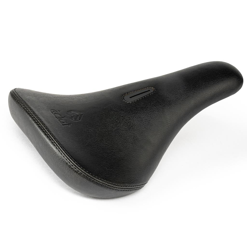 The Eclat Exile Pivotal Seat is a black padded ergonomic BMX seat with a textured surface, visible stitching, and a small central rectangular cutout. It features a Pivotal seat base for secure and easy mounting.