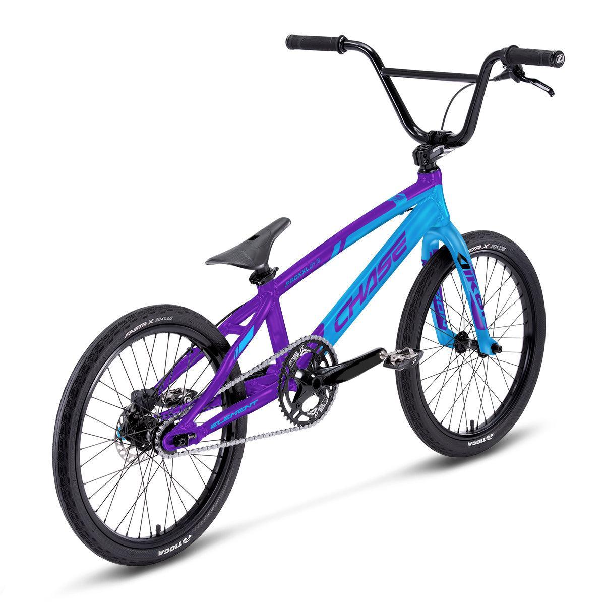 A Chase Element Expert Race Bike (2027) in blue and purple, featuring a 7005 T6 alloy frame, black tires, black handlebars, and a black seat, viewed from the back left side against a white background.