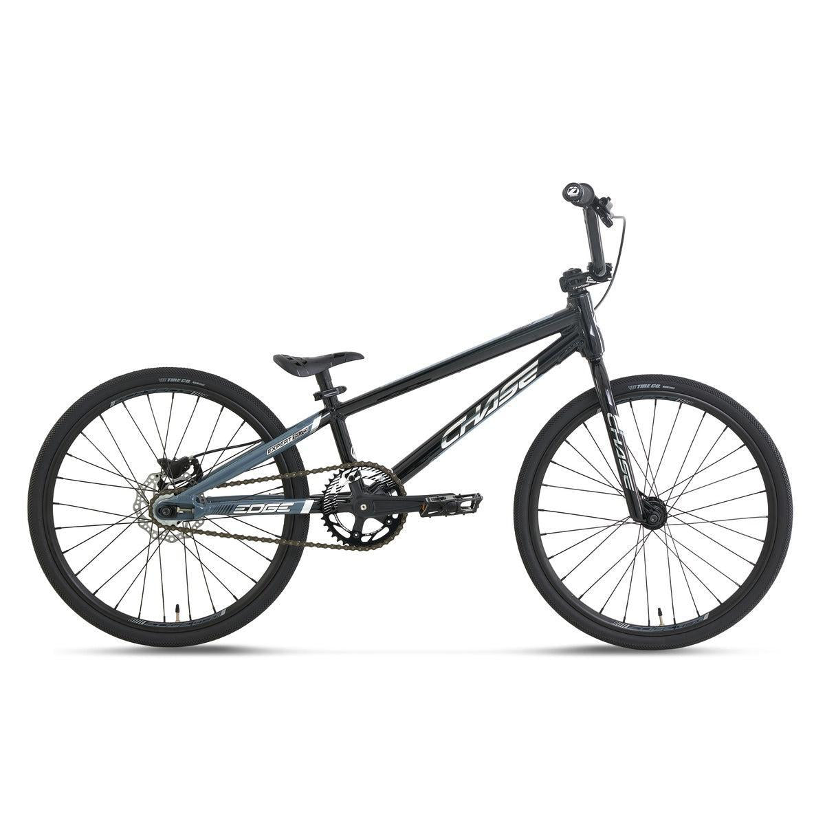 The Chase Edge Expert Race Bike (2027) is shown in profile on a white background, featuring a lightweight aluminum frame, integrated head tube, flat handlebars, single gear, and 20-inch wheels in a sleek black finish.