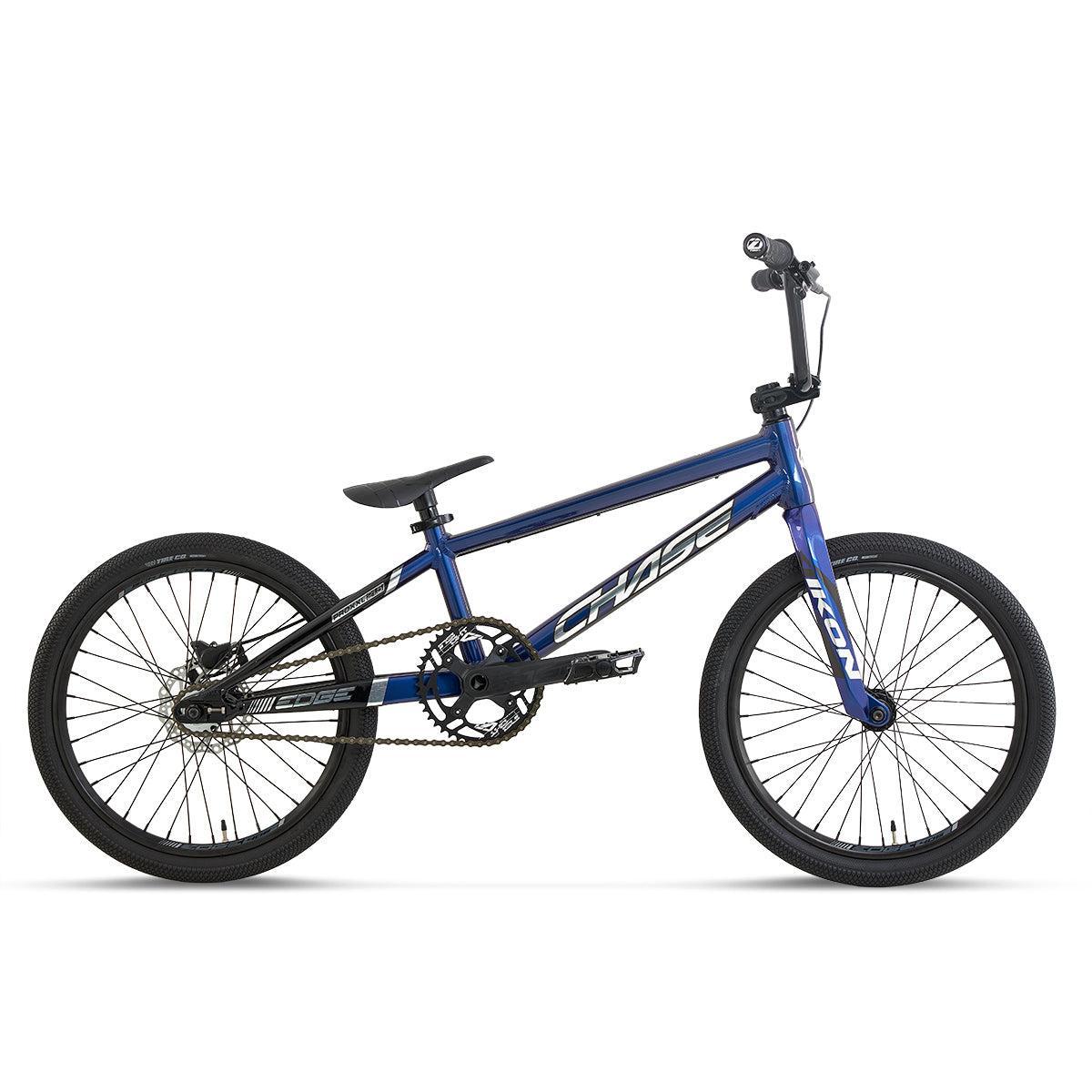 The Chase Edge Expert XL CF Race Bike (2027) is a blue BMX-style bicycle featuring a compact frame, single gear, straight handlebars, and black tires. Shown in profile against a white background, this model takes inspiration from the Chase Edge CF race bike and is equipped with a lightweight carbon fork to boost performance.