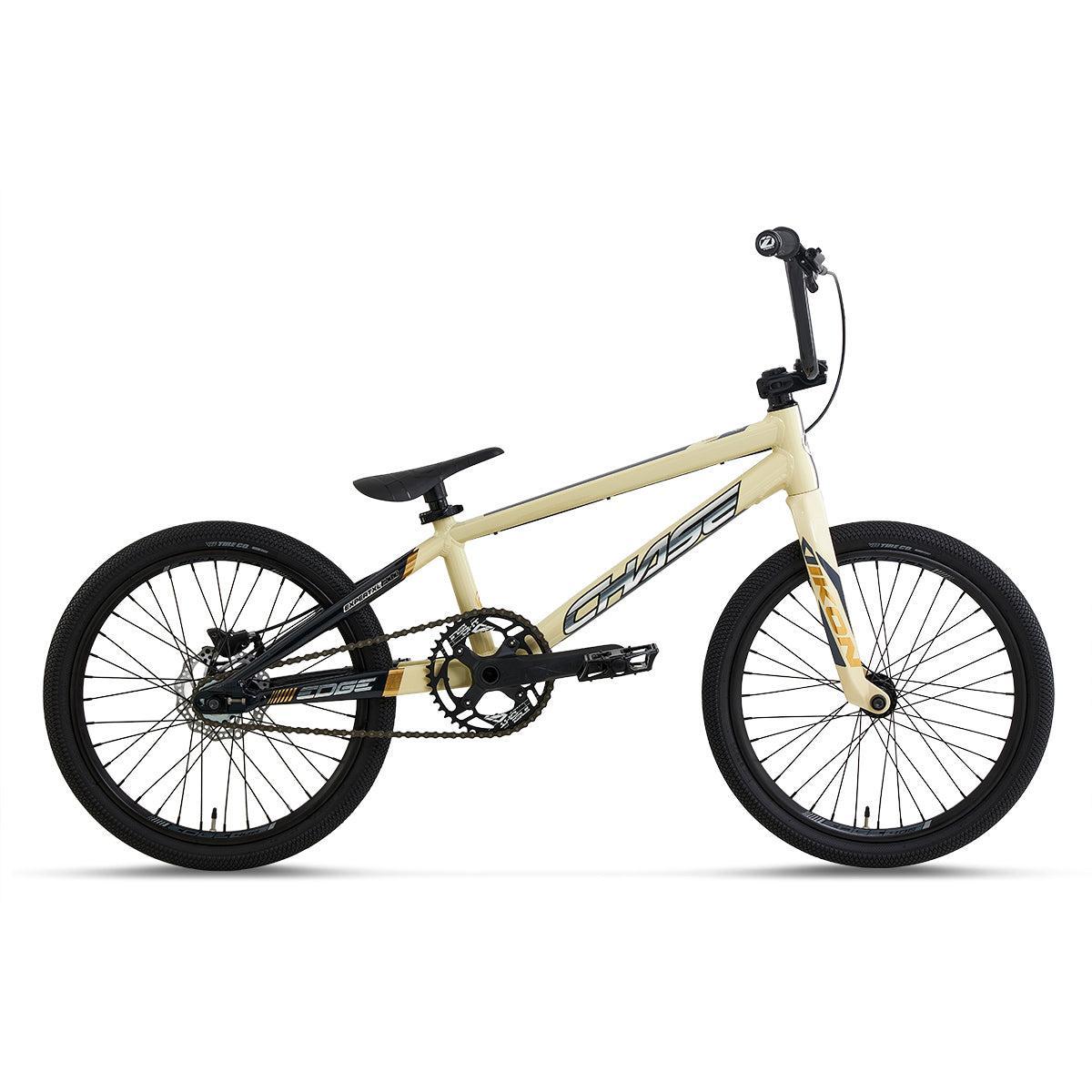 Side view of the Chase Edge Expert XL CF Race Bike (2027) in beige and black, featuring a lightweight frame, carbon fork, single gear, flat handlebars, and black tires on a white background.
