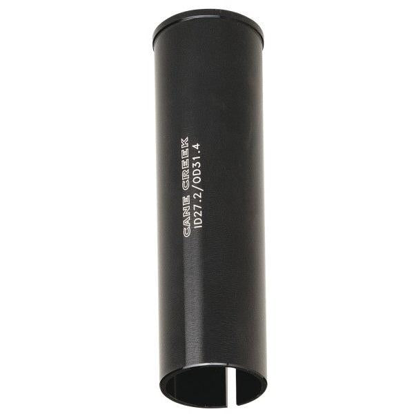 Black cylindrical Cane Creek 26.6 to 25.4 Seat Post Shim with a vertical slit at the bottom and white branding text on the side.