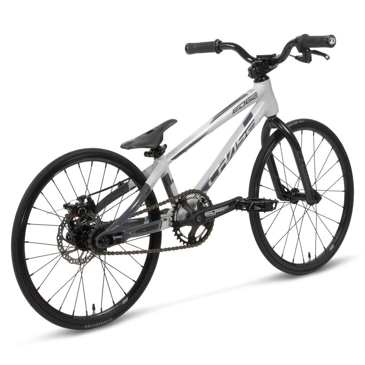 The Chase Edge Micro 18 Bike (2026) is a white and black BMX race bike with a lightweight 6061 aluminum frame, flat handlebars, and knobby tires, shown from a rear-side angle on a white background.