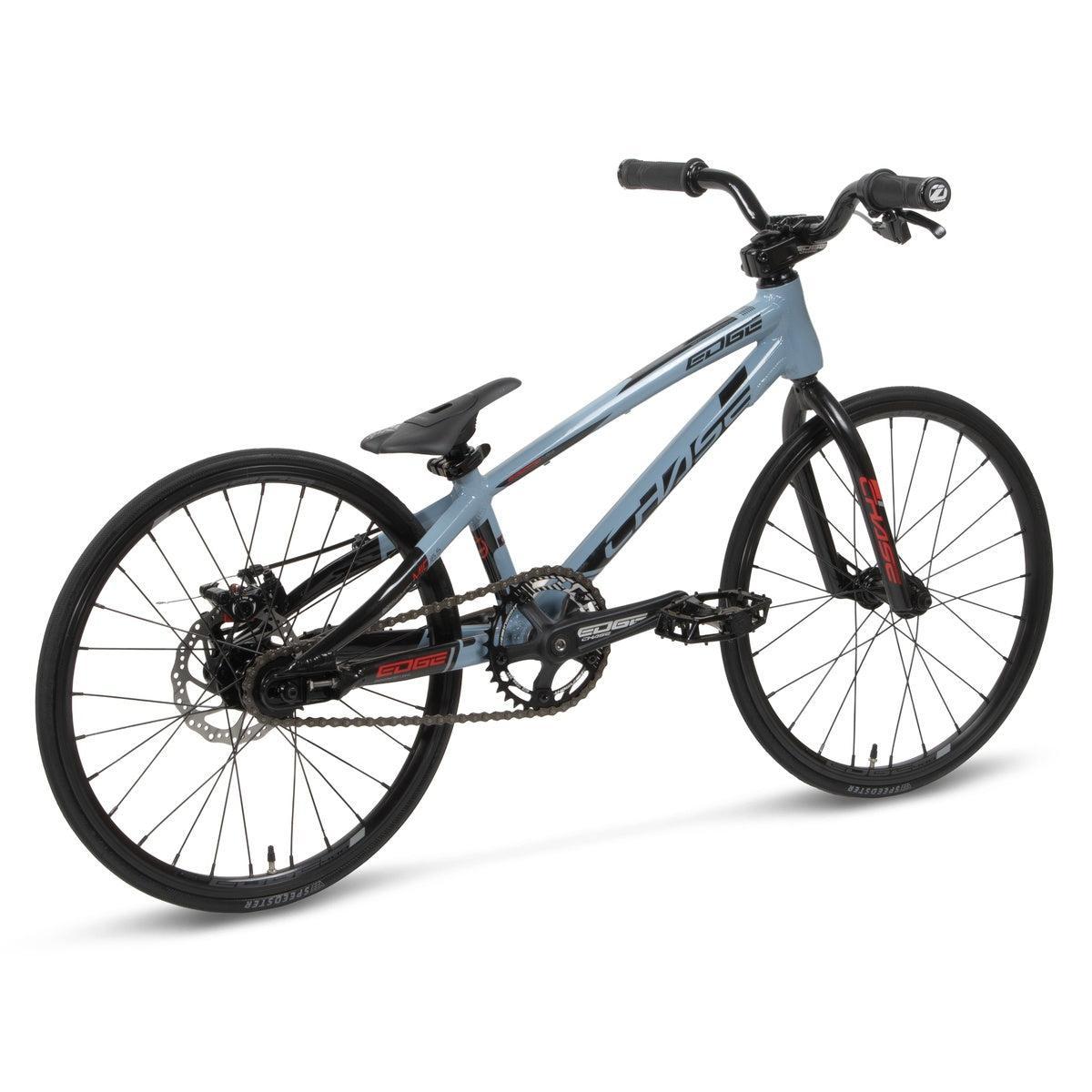 The Chase Edge Micro 18 Bike (2026) is a light blue and black BMX race bike with drop handlebars, thin tires, and a streamlined 6061 aluminum frame, shown from a rear side angle on a white background.