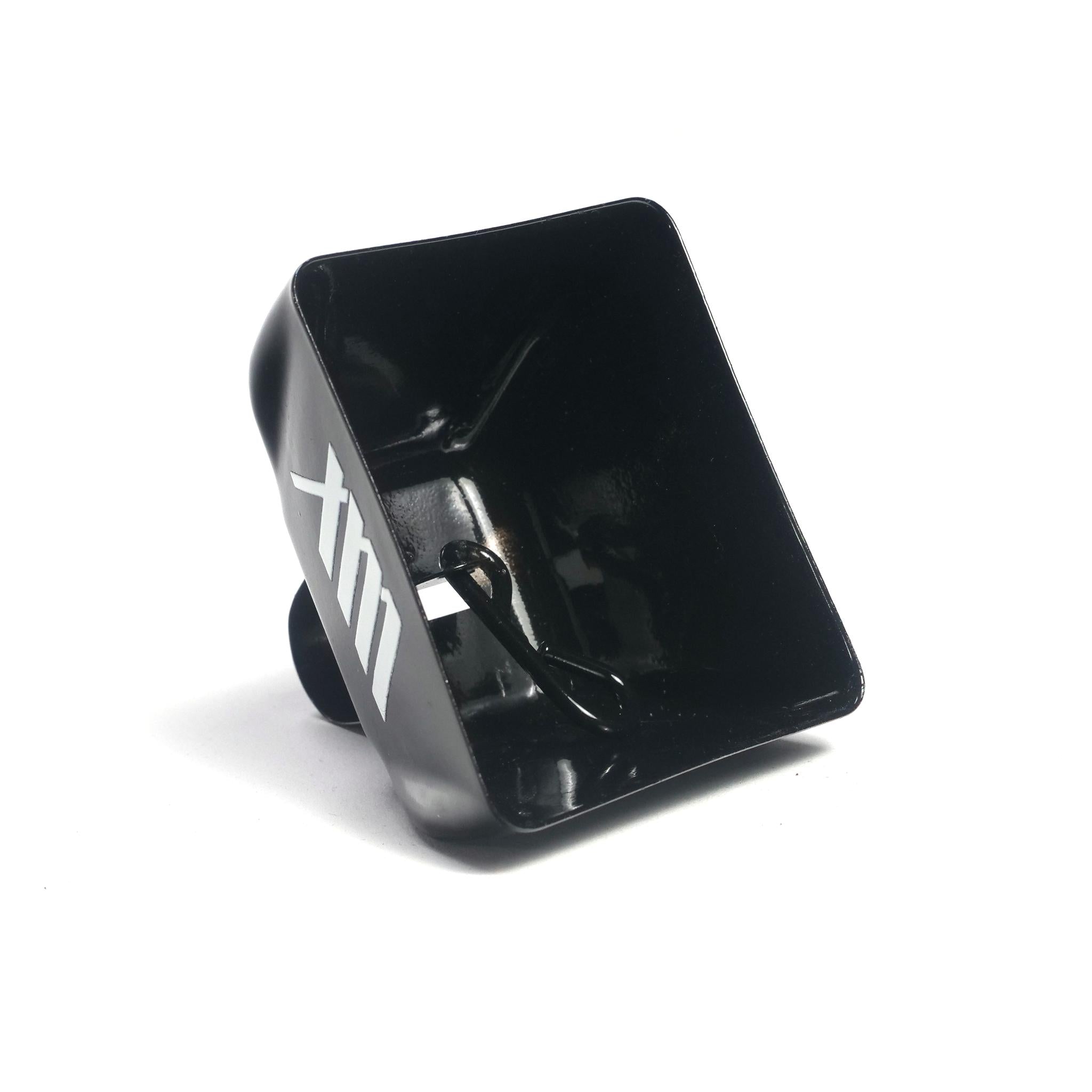 A black, square-shaped plastic scoop with a handle, featuring the white letters "XTM" on the side, is shown on a white background—perfect for trackside cheering when paired with your favorite LUXBMX Supporters Cowbell.
