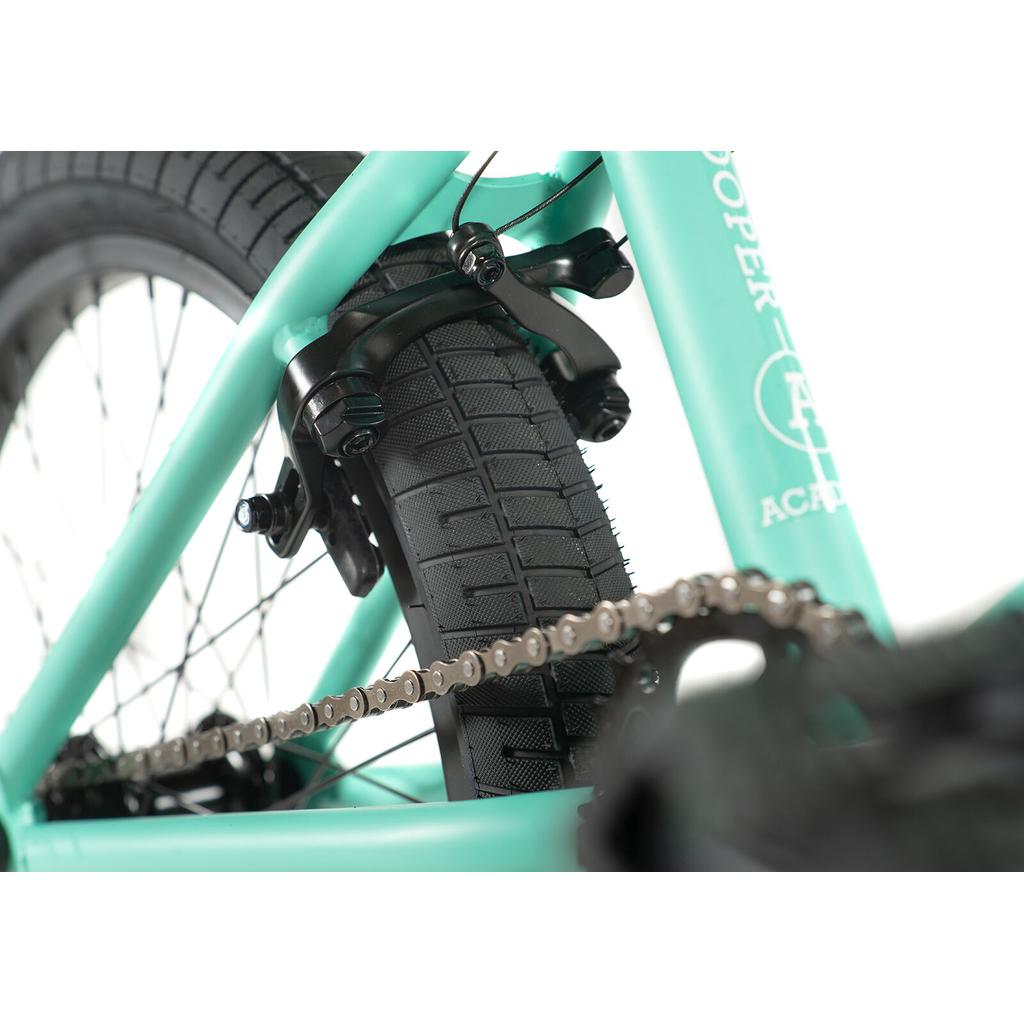 Close-up of the Academy Trooper 20 Inch Bike’s rear wheel, tire, and chain with a teal frame and black brake calipers.