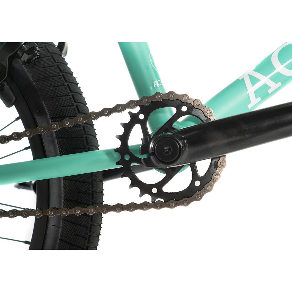 Close-up view of the Academy Trooper 20 Inch Bike's crankset, chainring, and chain, with part of the rear tire and teal frame visible.