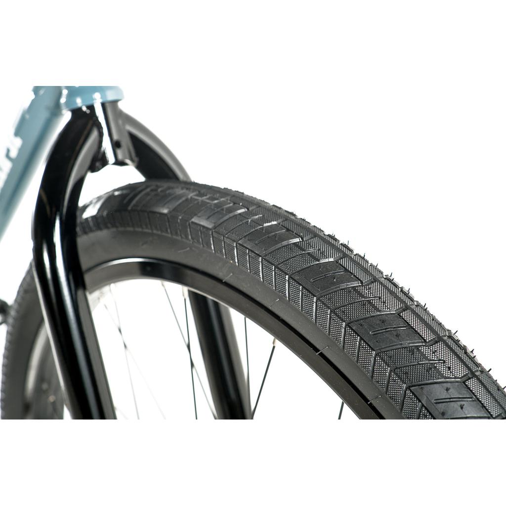 Close-up of a Colony Eclipse 26 Inch Bike’s front wheel, highlighting tire tread, rim, and black fork against a white background—an ideal detail shot for cruiser or chromoly frame fans.