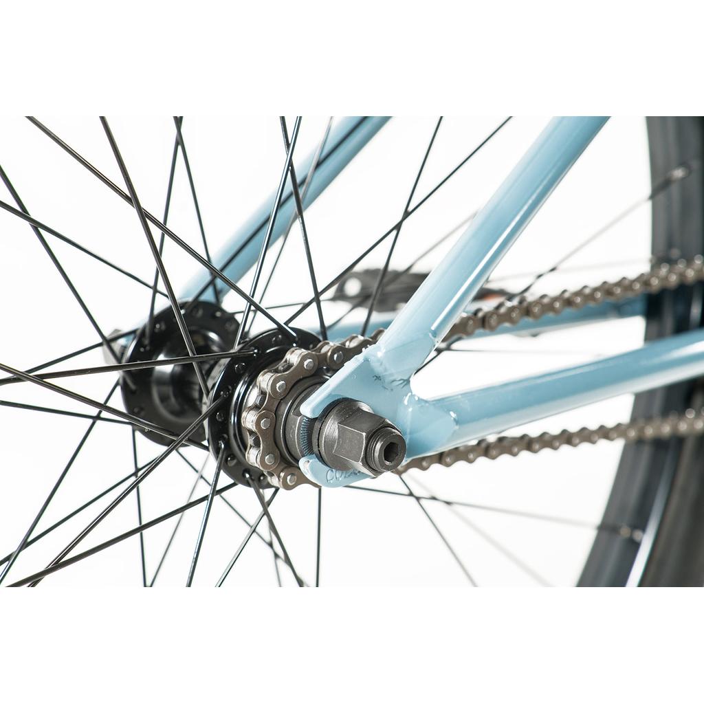 Close-up of the Colony Eclipse 26 Inch Bike’s rear wheel, showing the axle, chain, gear cog, and light blue chromoly frame.
