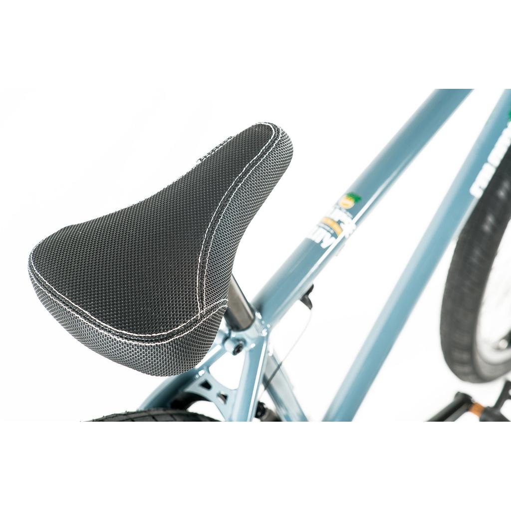 Close-up of a black cruiser seat with white stitching on a blue Colony Eclipse 26 Inch Bike, showing part of the rear tire and seat tube.