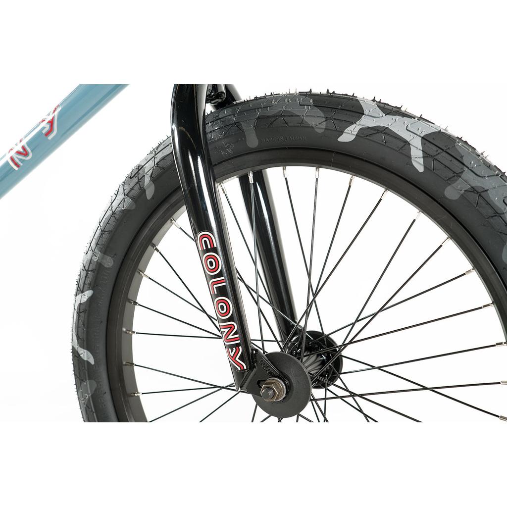 Close-up of the Colony Emerge 20 Inch Bike’s front wheel with black spokes and a black fork labeled "COLONY" on a white background, highlighting this quality BMX bike.