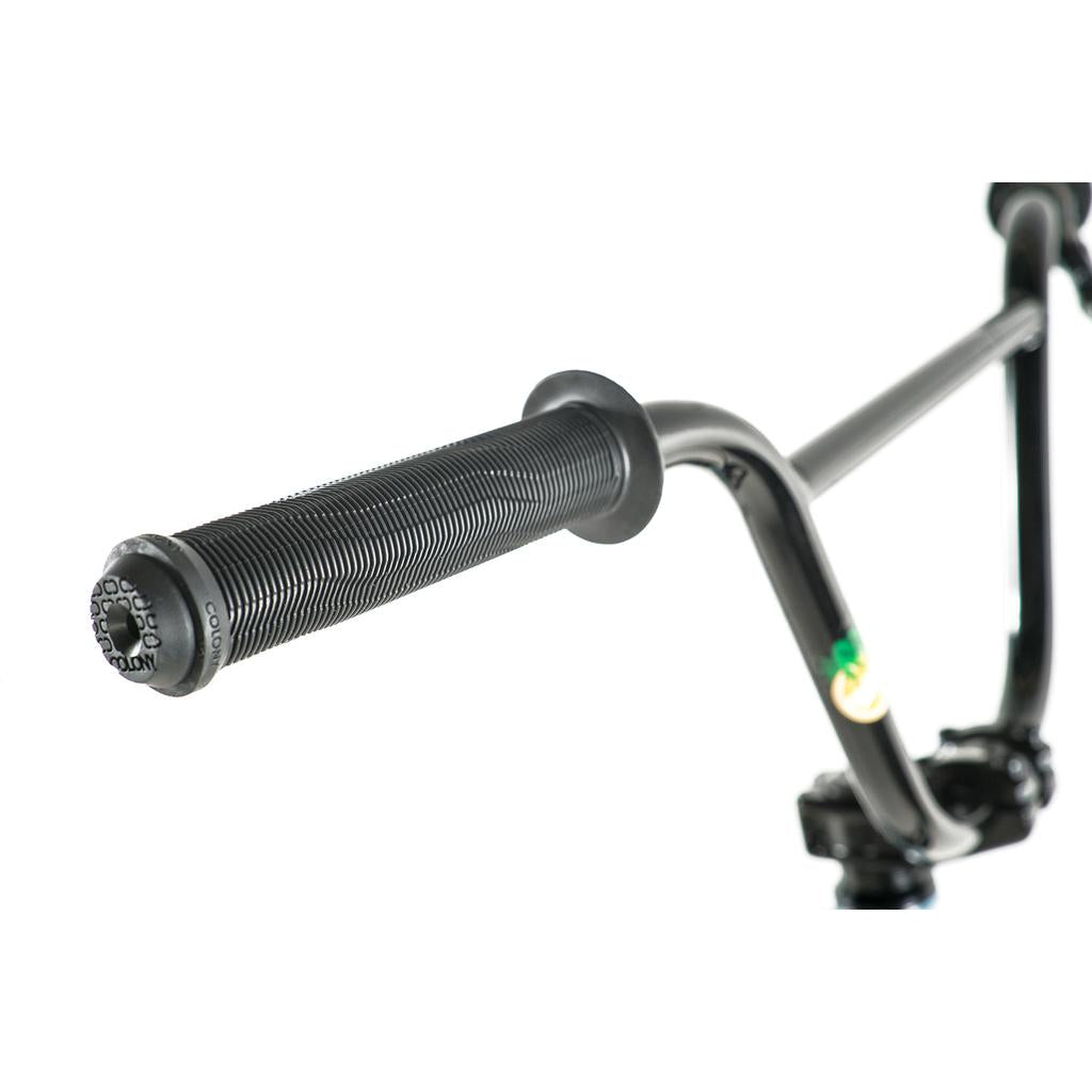 Close-up view of a black handlebar with textured rubber grip and plastic end cap, featured on the Colony Eclipse 24 Inch Bike BMX cruiser, set against a white background.