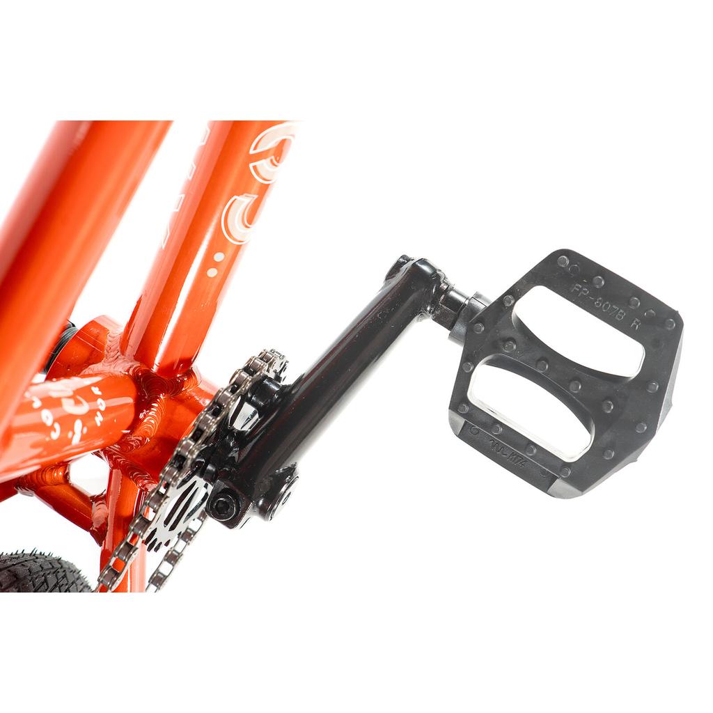 Close-up of a bicycle pedal and crank arm attached to an orange Colony Horizon 14 Inch Bike frame, showing part of the chain and chainring.