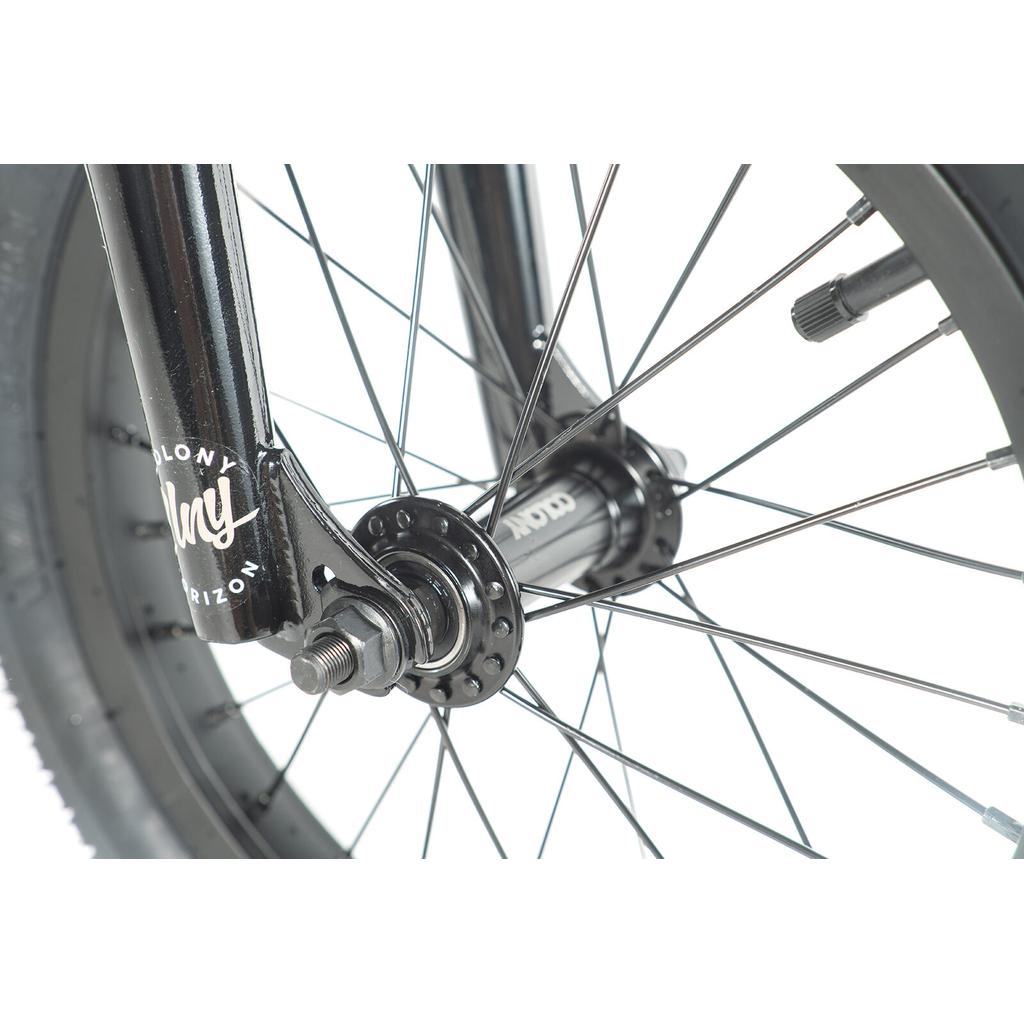 Close-up of a black bicycle front wheel featuring metal spokes, axle, and hub with visible branding on the fork—a quality detail of BMX bikes like the Colony Horizon 14 Inch Bike with its lightweight alloy frame.