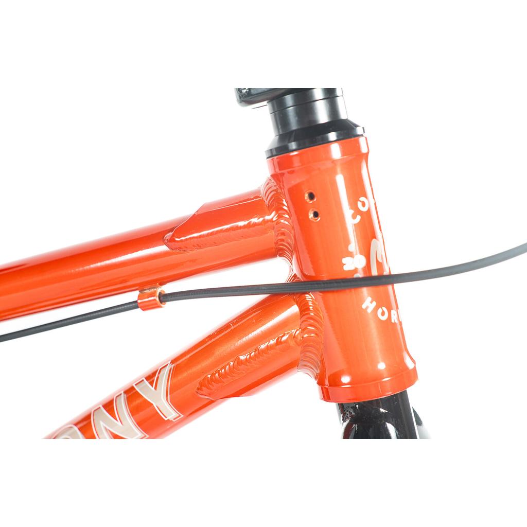 Close-up of the Colony Horizon 14 Inch Bike in orange, highlighting its lightweight alloy frame with head tube, top tube, down tube, and a cable routed along the frame.