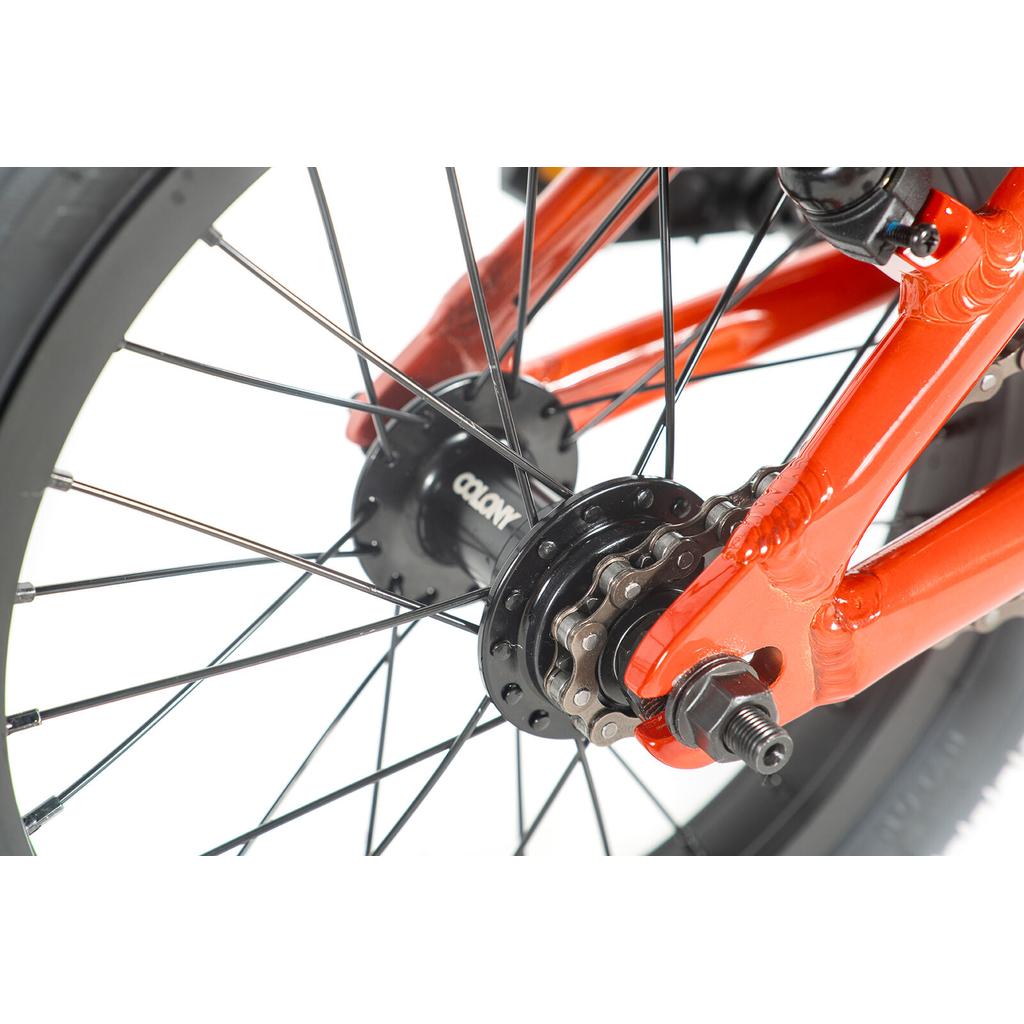 Close-up of the rear wheel and gear system on a red Colony Horizon 14 Inch Bike, highlighting the lightweight alloy frame, spokes, hub, chain, and axle against a white background.