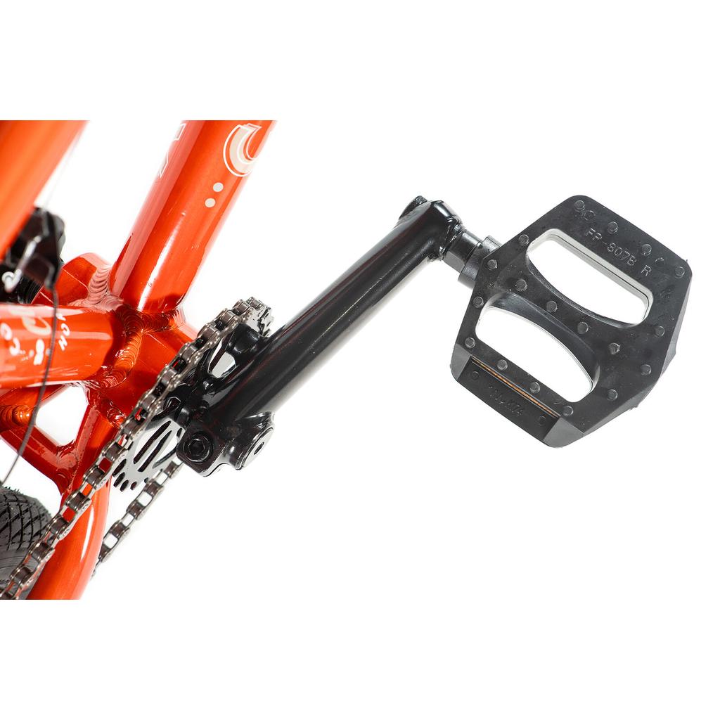 Close-up of a black pedal and crank arm on an orange Colony Horizon 16 Inch Bike, featuring part of the chain and gear system—ideal for freestyle riders.