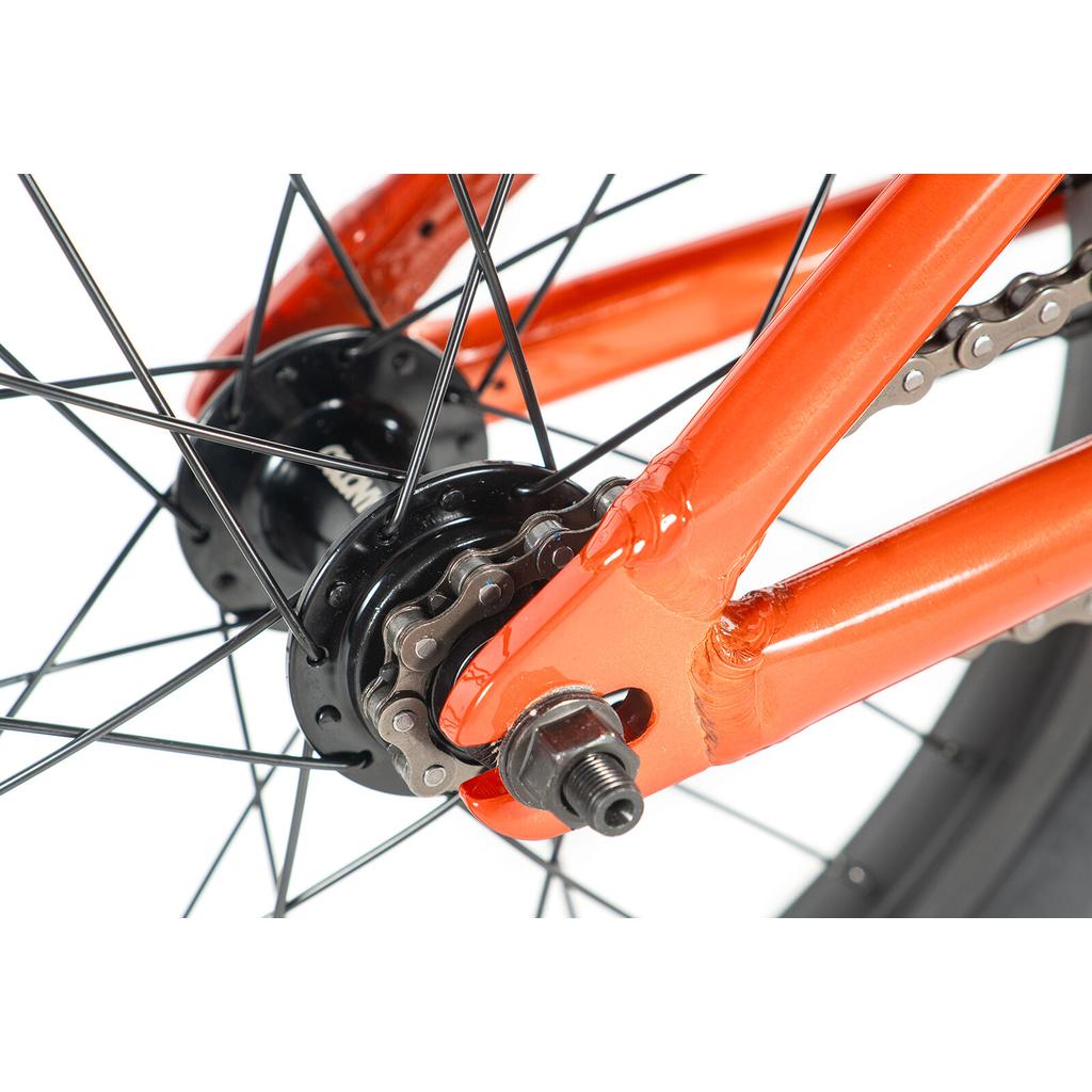 Close-up of the rear wheel hub, chain, and orange frame of the Colony Horizon 16 Inch Bike, showing spokes, axle nut, and tire—ideal for freestyle riders and Colony fans.