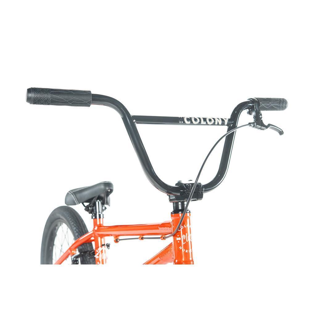 Close-up of the handlebars and front section of an orange Colony Horizon 18 Inch Bike featuring a visible Colony logo, ideal for BMX freestyle enthusiasts.