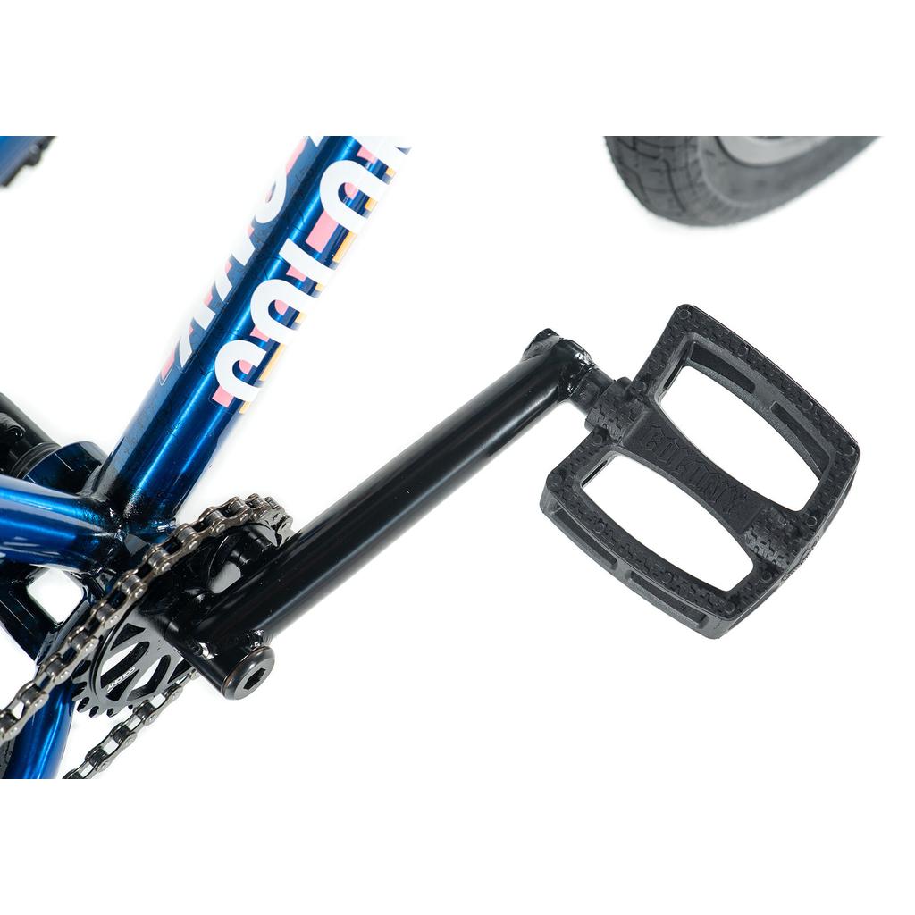 Close-up of the Colony Premise 20 Inch Bike's blue chromoly frame, showcasing the pedal, crank arm, partial chain, rear tire, and double-wall rims against a white background.