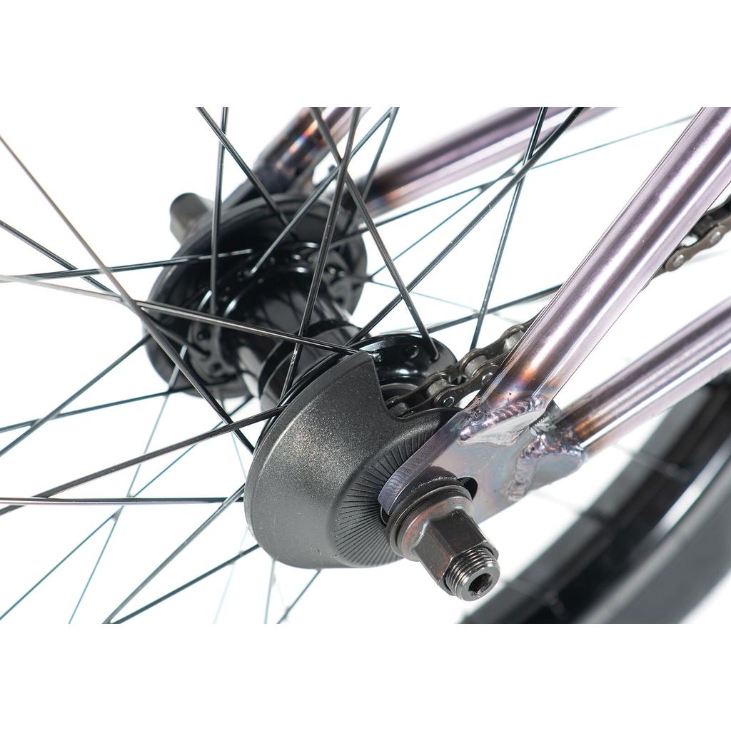 Close-up of the Colony Rico Elite 20 Inch Bike’s rear wheel, showcasing black spokes, axle nut, chain, and part of the metal frame built for pro-level BMX performance.