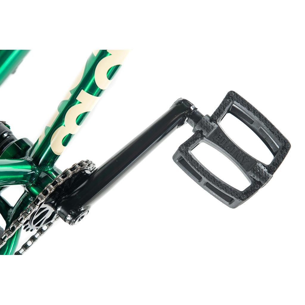 Close-up of a Colony Cadet Elite 20 Inch Bike crankset with a black pedal on a metallic green BMX frame, showing the chain and part of the pro-level BMX gearing mechanism.