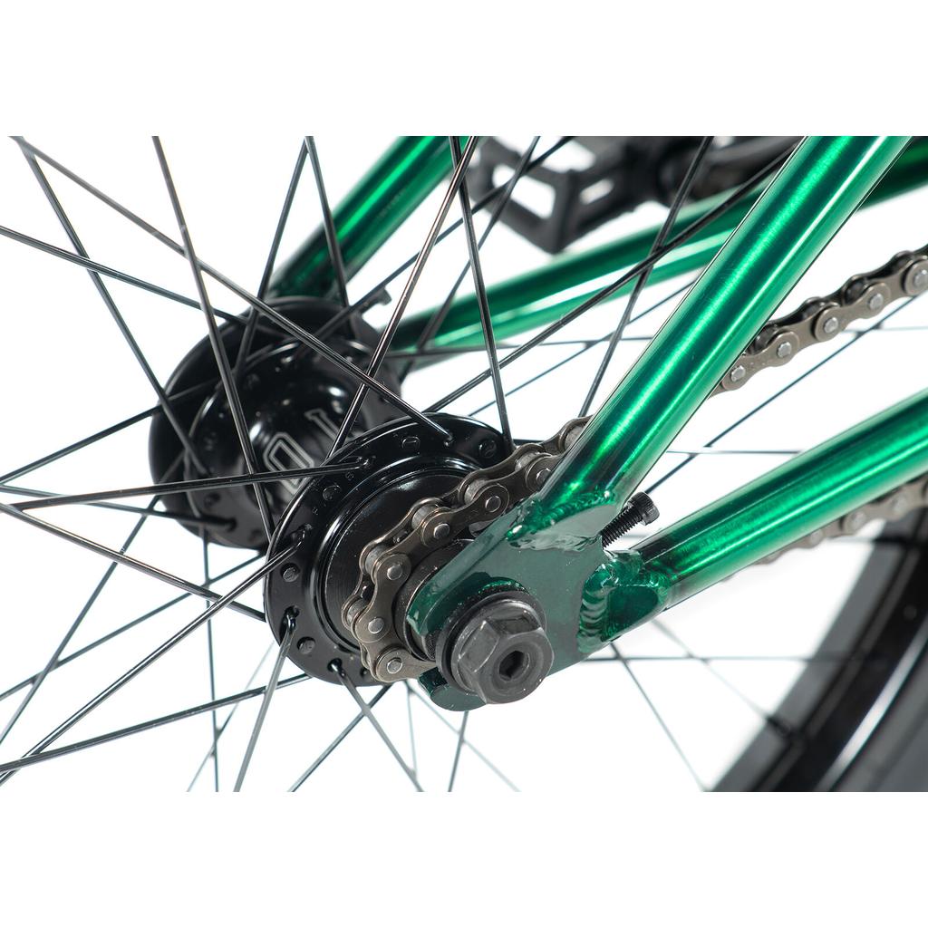 Close-up of the Colony Cadet Elite 20 Inch Bike’s rear wheel, showcasing its green frame with black hub, chain, and spokes set against a white background.