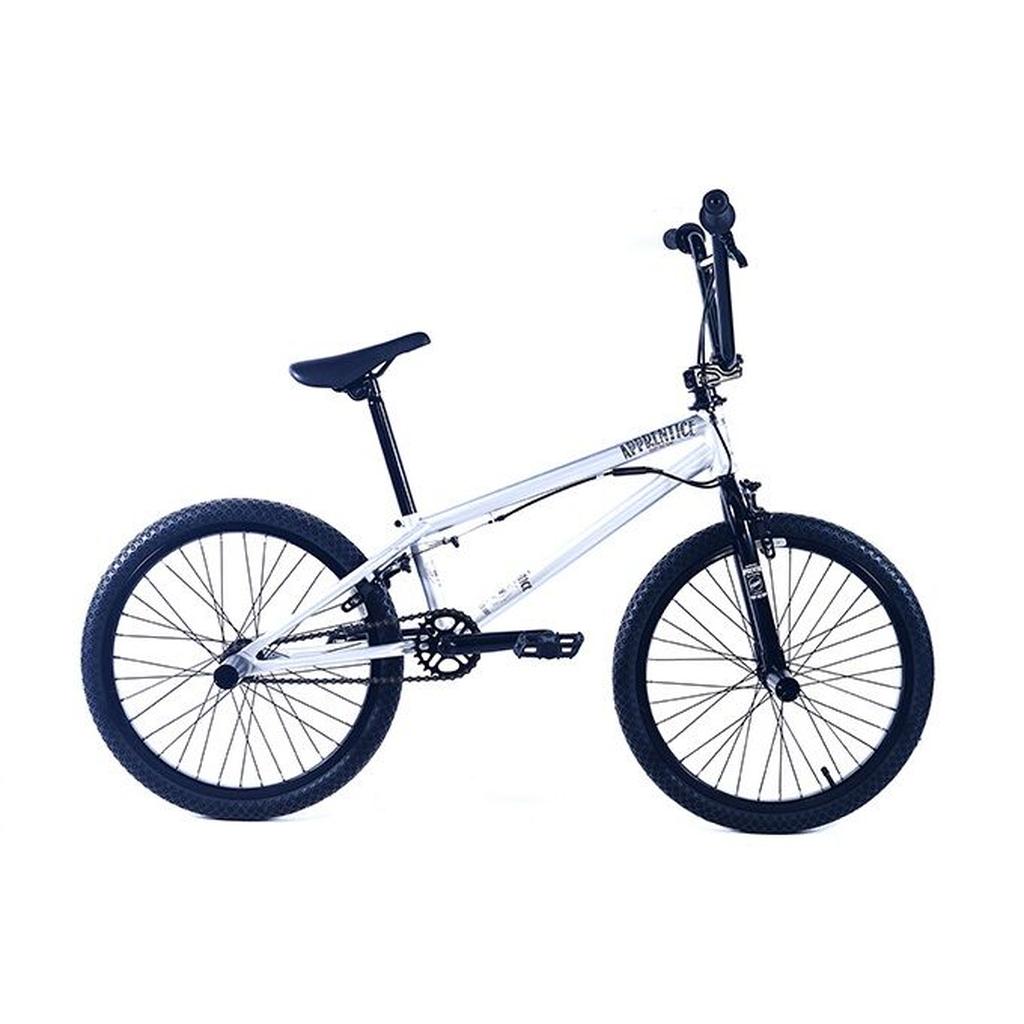 The Colony Apprentice Flatland 20 Inch Bike is shown in profile, featuring a white frame with black handlebars, seat, tires, and BMX bike pegs against a plain white background.