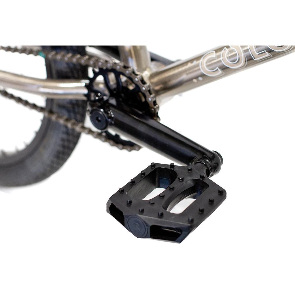 Close-up of the Colony Horizon 18 Inch Bike crank arm and black pedal on the chainring, showing part of its lightweight alloy frame and rear wheel.