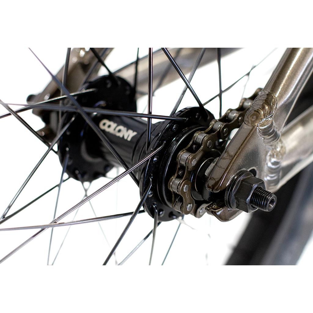 Close-up of the Colony Horizon 18 Inch Bike’s rear wheel hub, highlighting metal spokes, chain, gears, axle nut, and part of its lightweight alloy frame.