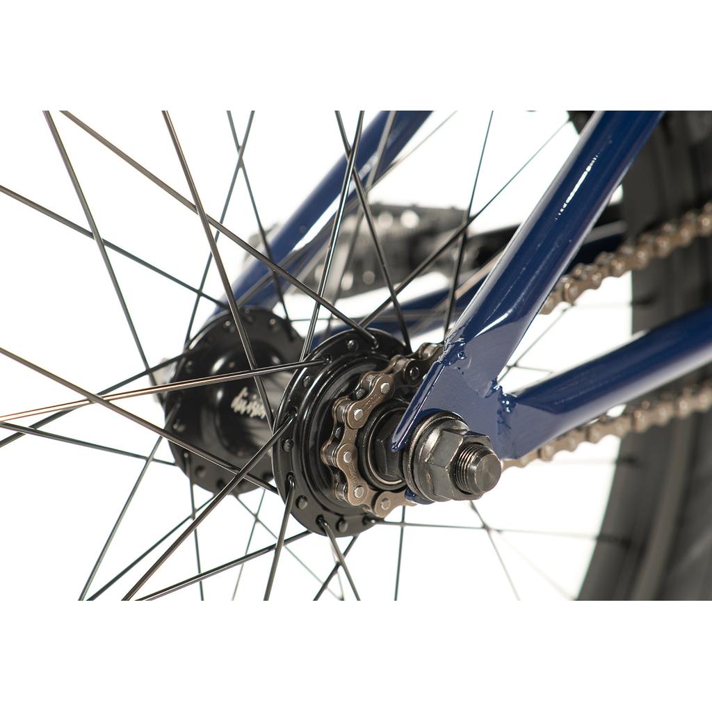 Close-up of the Division Reark 20 Inch Bike's rear wheel, highlighting the chain, sprocket, spokes, and rear dropout on its blue lightweight Hi-Tensile steel frame.
