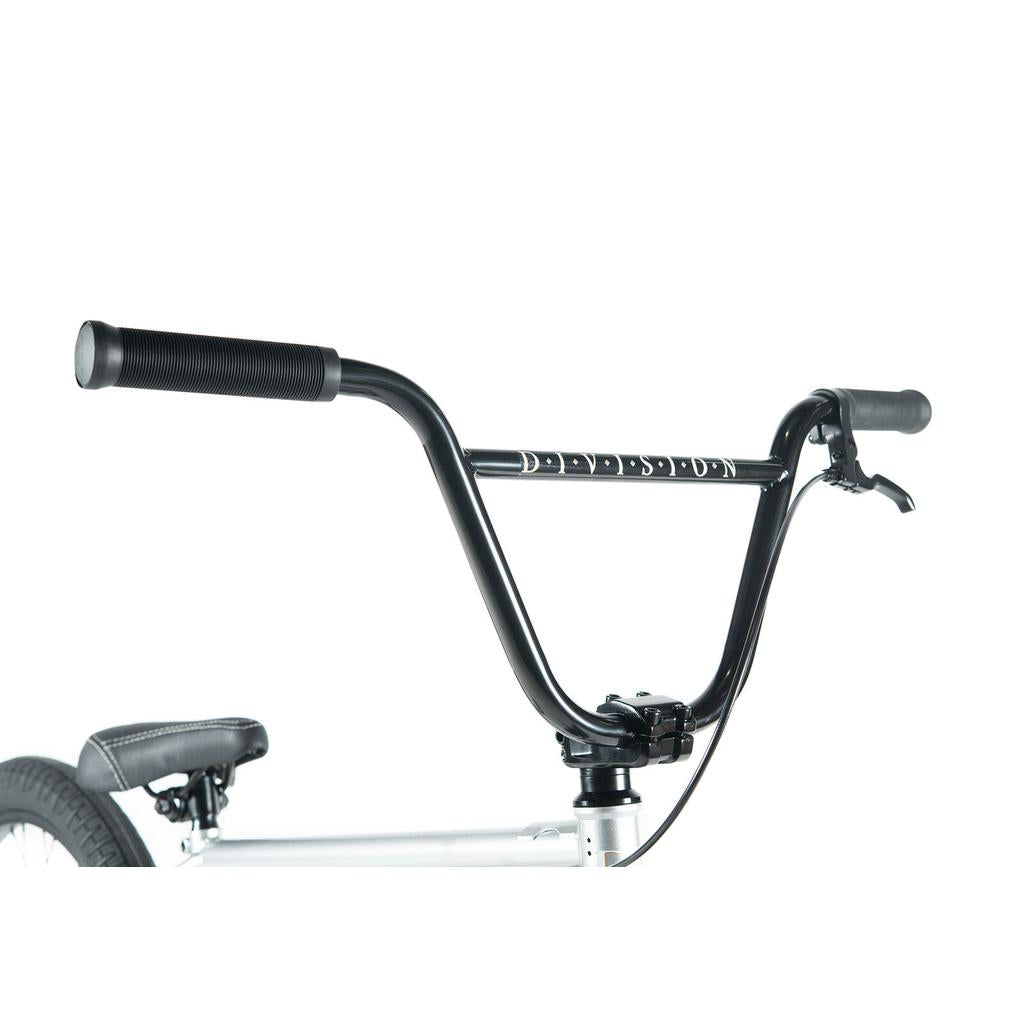 Close-up of a black BMX handlebar with grips and brake lever on a silver Division Reark 20 Inch Bike. "DECEPTION" is printed on the handlebar. Durable 3-piece cranks enhance the bike's style and strength.