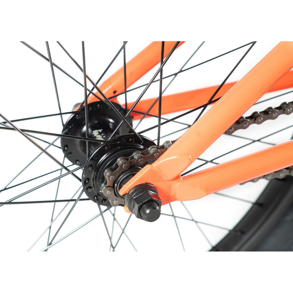 Close-up of the orange Division Reark 20 Inch Bike frame, highlighting the rear wheel hub, chain, spokes, and axle. Features lightweight Hi-Tensile steel construction and 3-piece cranks. Displayed against a white background.