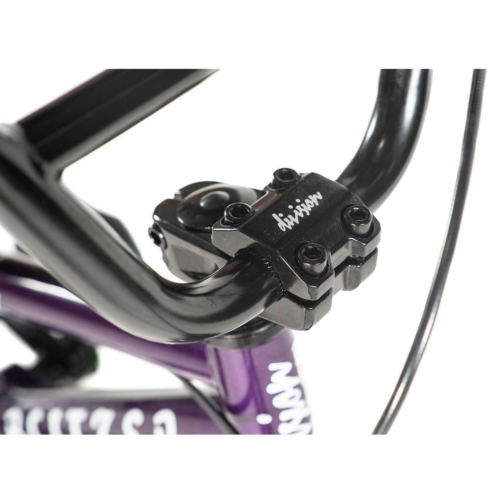 Close-up of the Division Blitzer 12 Inch Bike's black handlebar stem with visible bolts, mounted on its purple freestyle BMX frame.