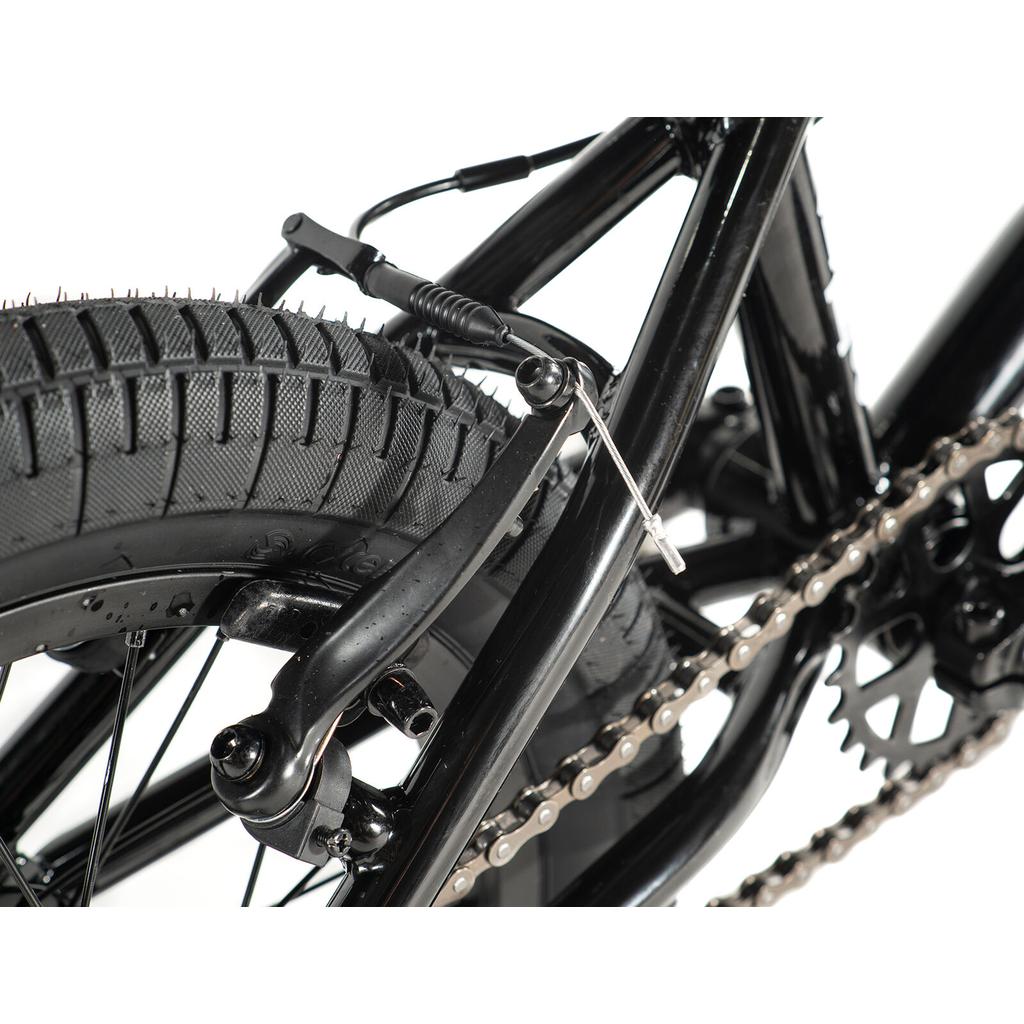 Close-up of the Division Blitzer 14 Inch Bike's rear wheel, featuring the tire, chain, sprocket, and V-brake system on 14-inch wheels.