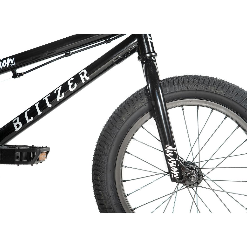 Close-up of the Division Blitzer 16 Inch Bike youth BMX, featuring black frame with "BLITZER" and "division" in white, showing the front wheel, fork, pedal, and part of the frame.